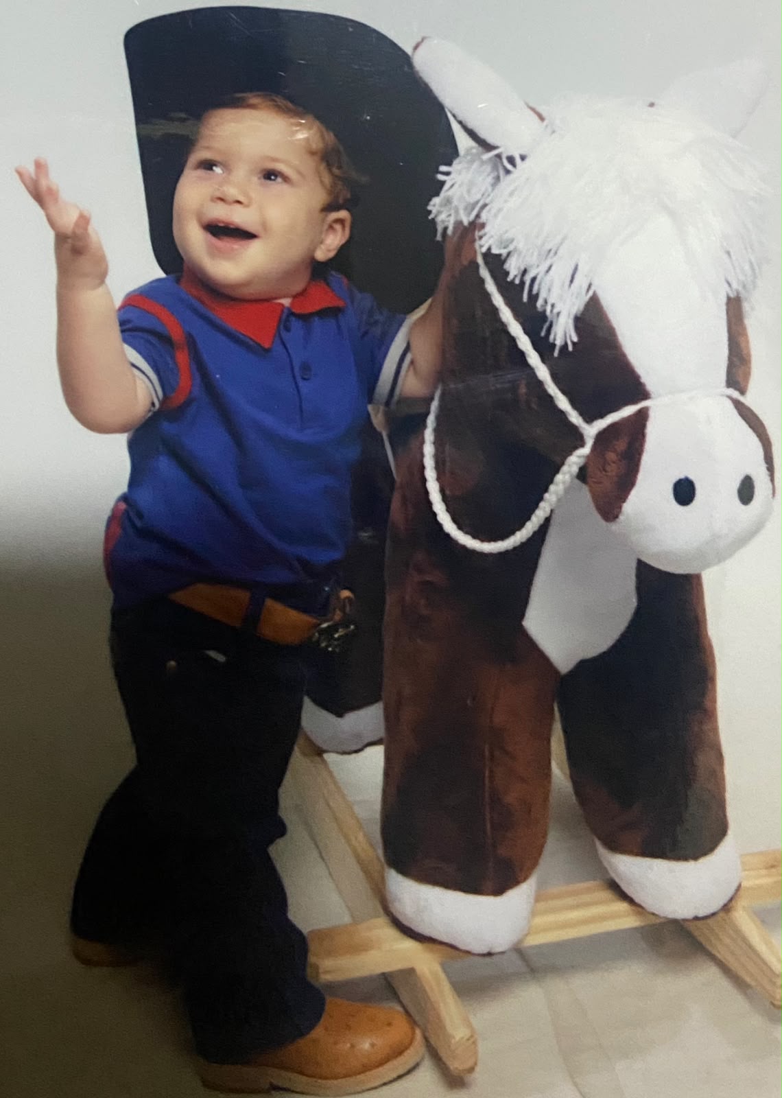 Miguel bebê de chapéu de cowboy ao lado do cavalinho